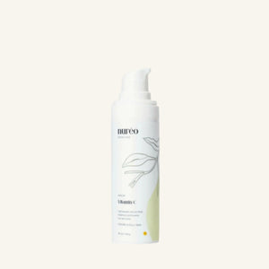 Radiant Boost Vitamin C Serum bottle on a green background.