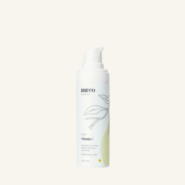 Radiant Boost Vitamin C Serum bottle on a green background.
