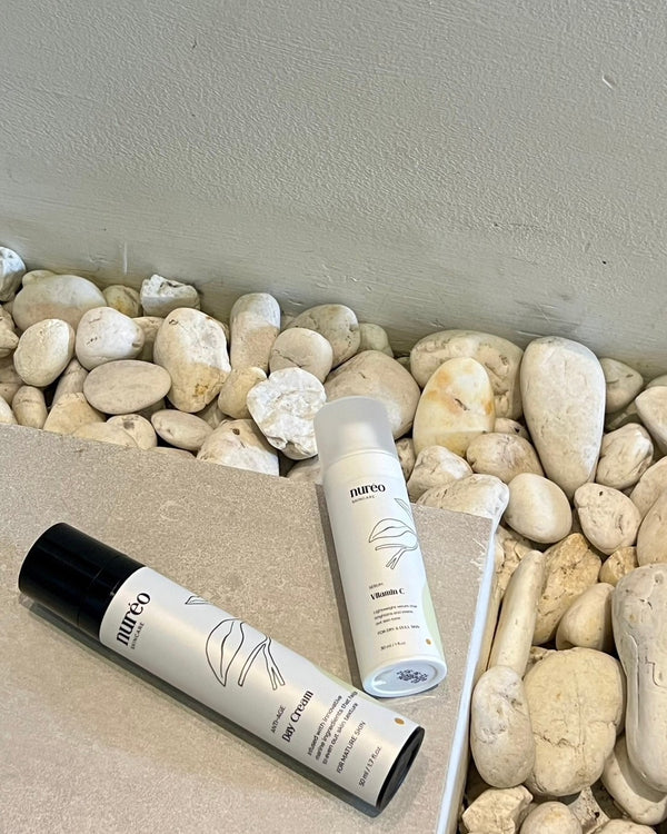 nuréo Vitamin C Serum and Anti-Age Day Cream on warm stone