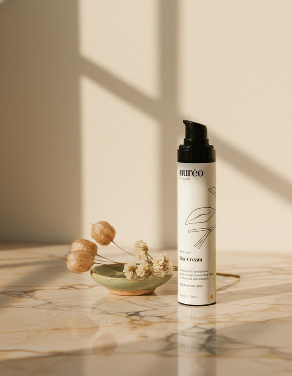 nureo GlowGuard Anti-Aging Day Cream on marble with dried flowers