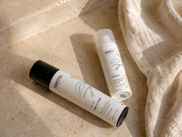 nuréo Vitamin C Serum and Day Cream in a styled limestone and linen scene